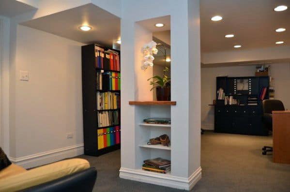 Basement with built-in bookcase pole, recessed lighting, and organized office area.