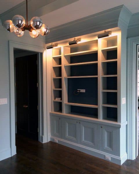 A stylish built-in bookcase with crown molding and modern lighting, enhancing a room's elegant design