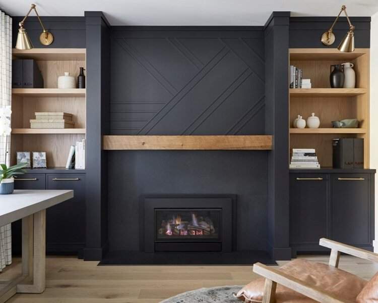 Modern living room with black built-in shelves, a fireplace, and wood accents for contrast.