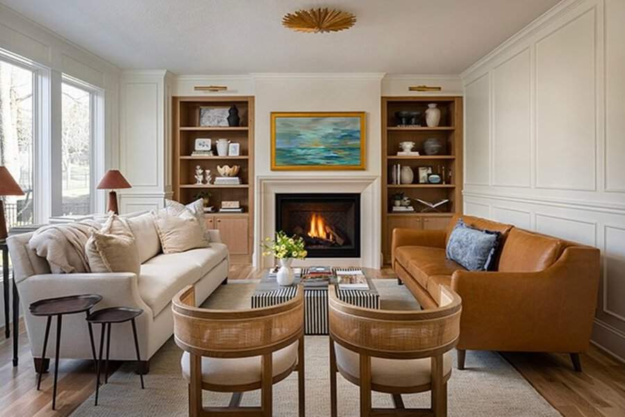 Elegant living room with built-in wooden shelves, a fireplace, and a mix of neutral and warm tones.