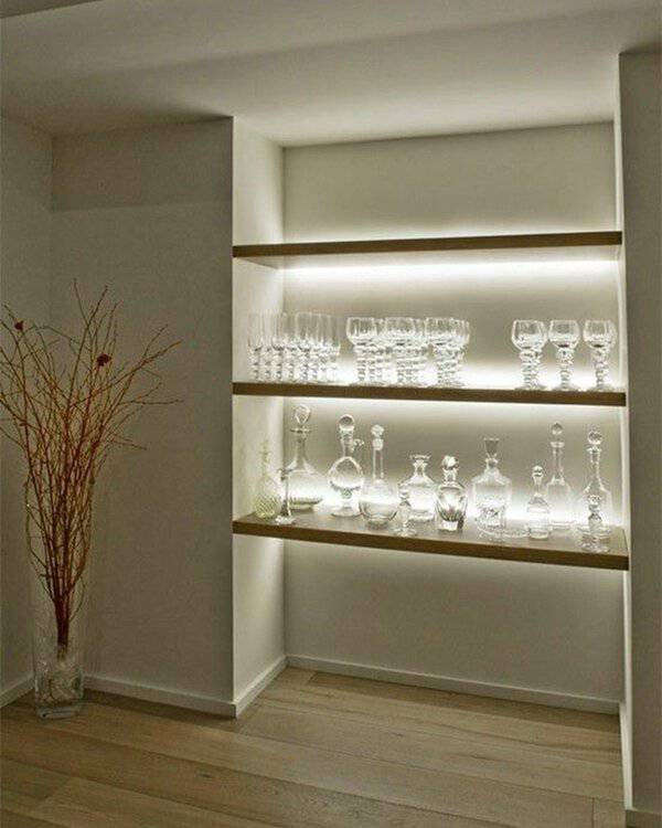 Built-in glass display shelves with LED lighting showcasing crystal glassware.