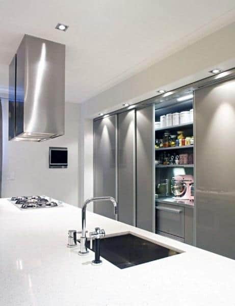 Modern kitchen with sliding pantry doors and sleek stainless steel accents.