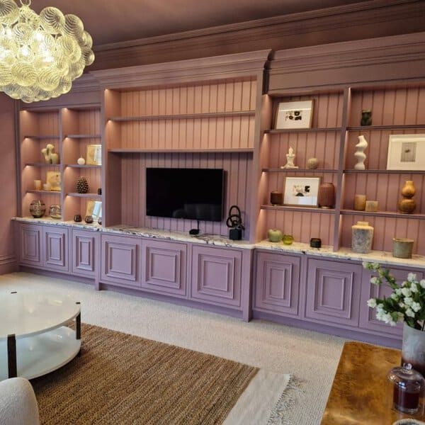 Elegant living room with mauve built-in shelves, decorative lighting, and a marble countertop.
