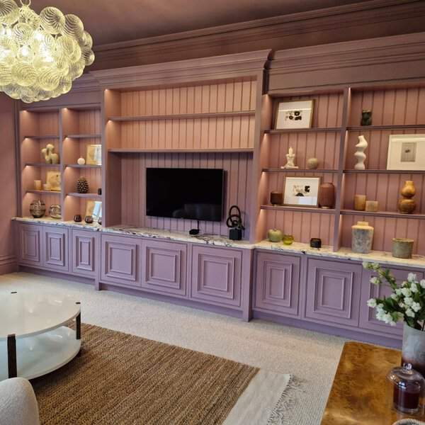 Elegant living room with mauve built-in shelves, decorative lighting, and a marble countertop.