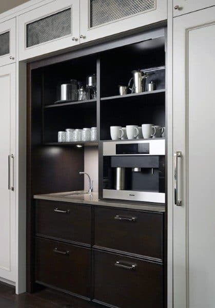 Built-in coffee bar with dark wood cabinets, open shelving, sink, and integrated coffee machine.