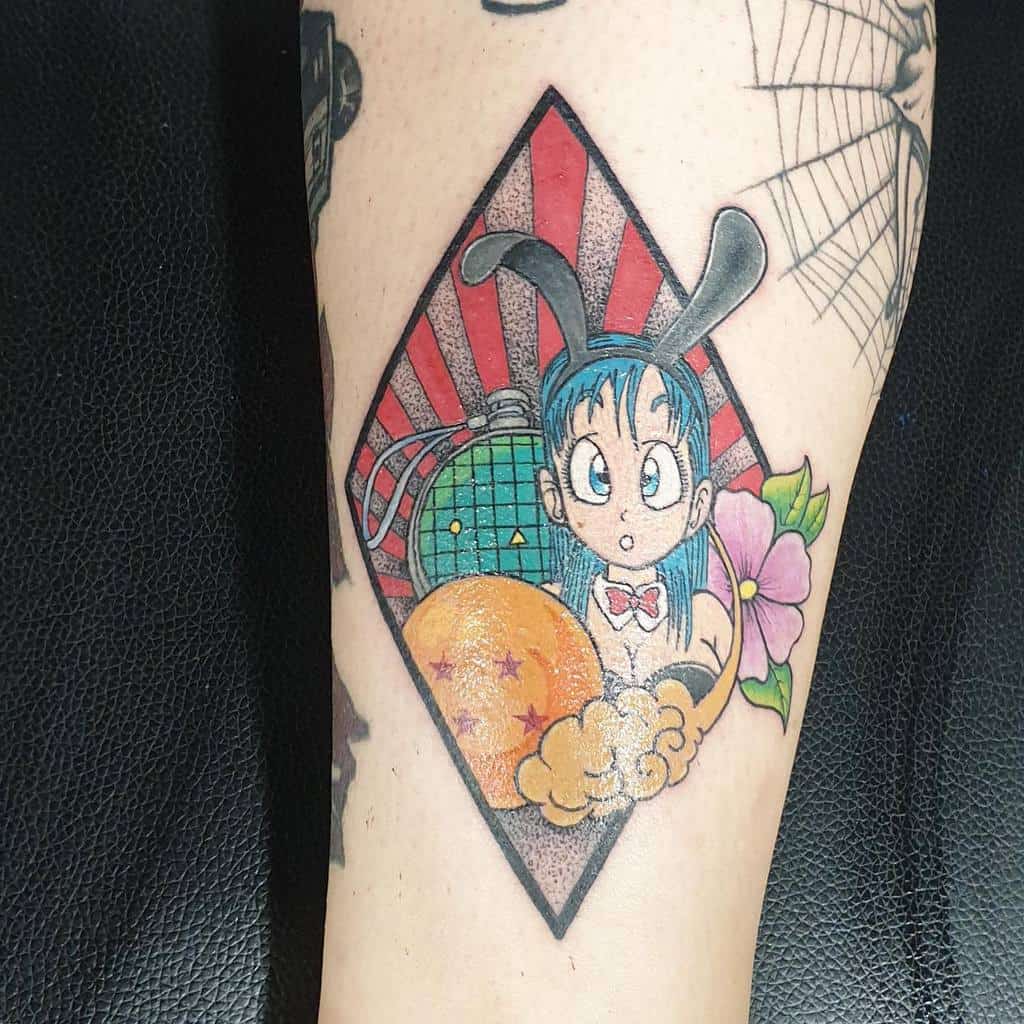 A tattoo of Bulma from Dragon Ball in a bunny outfit, holding a Dragon Ball with a bright flower and a red sunburst pattern in the background.