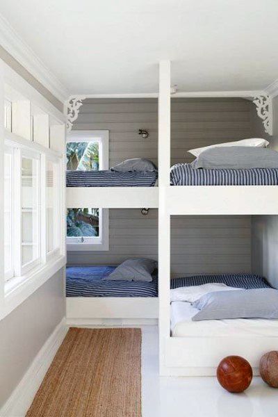 Bright and airy bunk beds with white frames, striped bedding, and elegant decorative details, perfect for small spaces