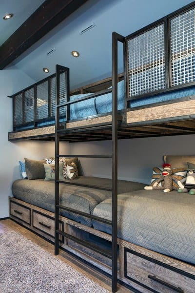 Bunk beds with metal frames, blue bedding, and stuffed animals enrich a cozy bunk-themed carpeted room