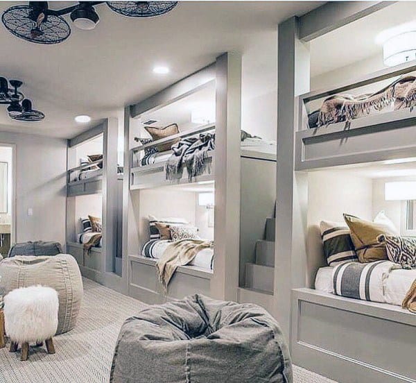 Cozy modern room with custom bunk beds, bean bags, and soft lighting; neutral tones create a relaxing atmosphere