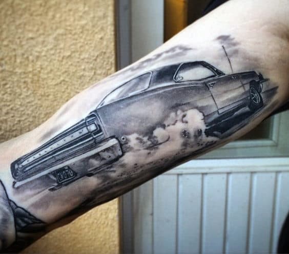 Tattoo of a classic car burning rubber located on a forearm