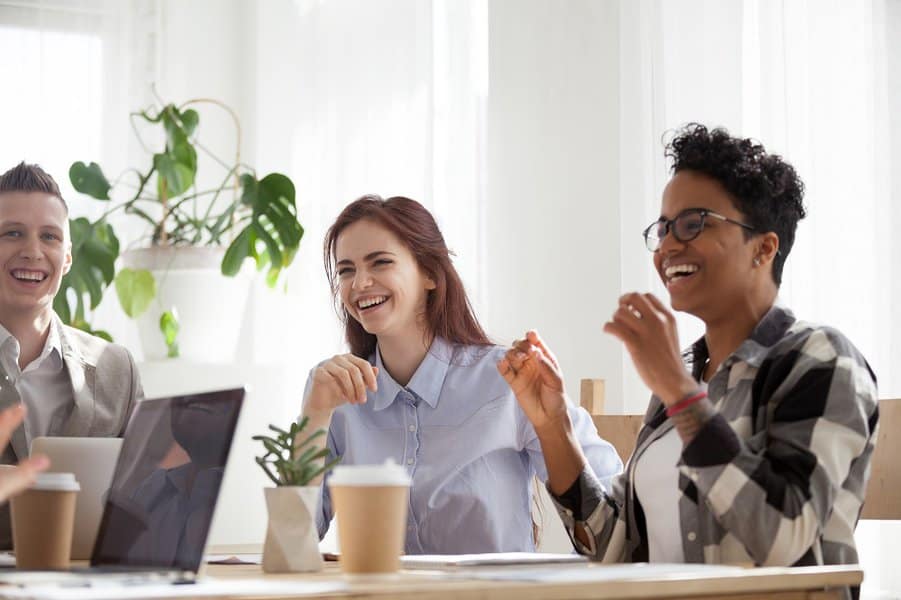 business people laughing at funny joke talking during break