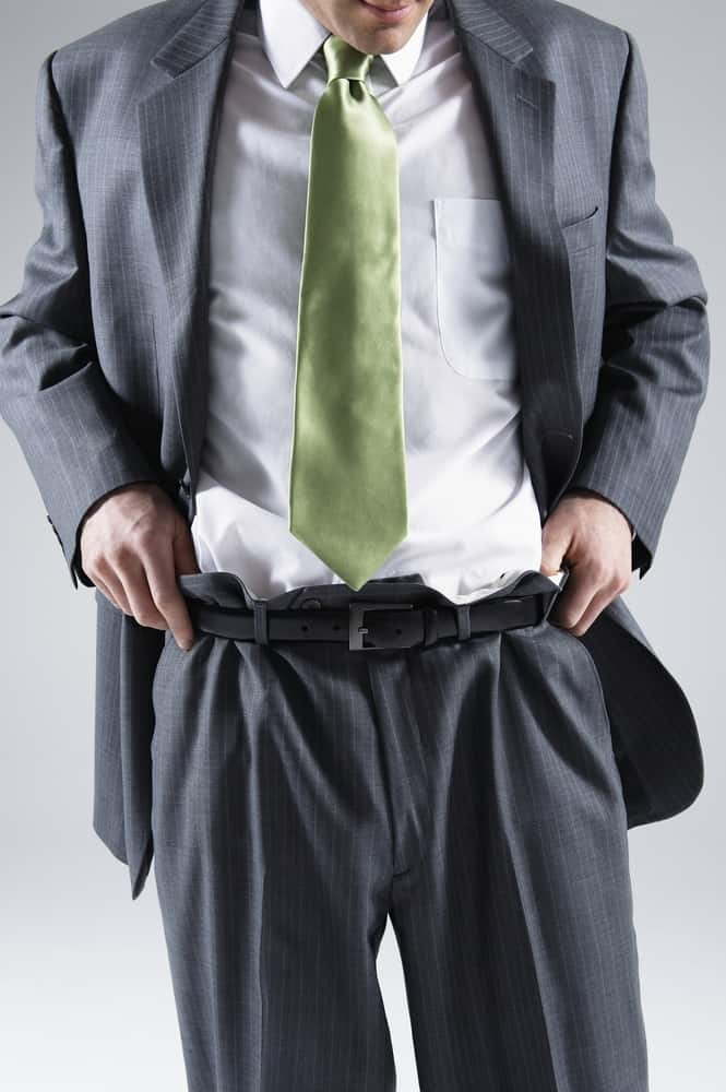 businessman pulling loose pant