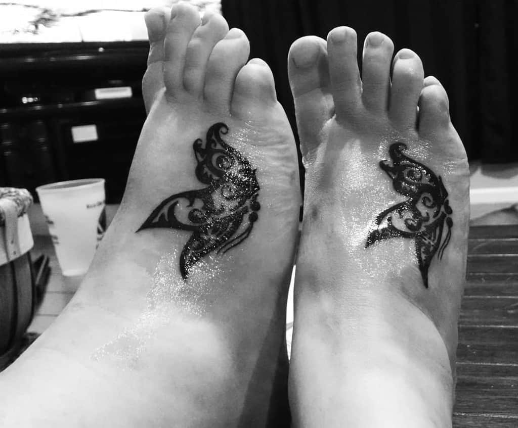Matching tribal angel wing tattoos symbolizing love, guidance, and an unbreakable bond.