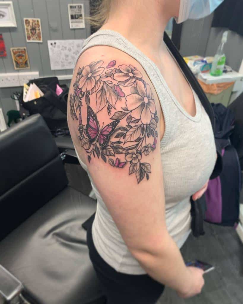 Woman with floral and butterfly tattoo on her upper arm