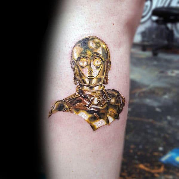 Realistic C-3PO tattoo with metallic gold shading and detailed reflections, creating a lifelike 3D effect on the skin.