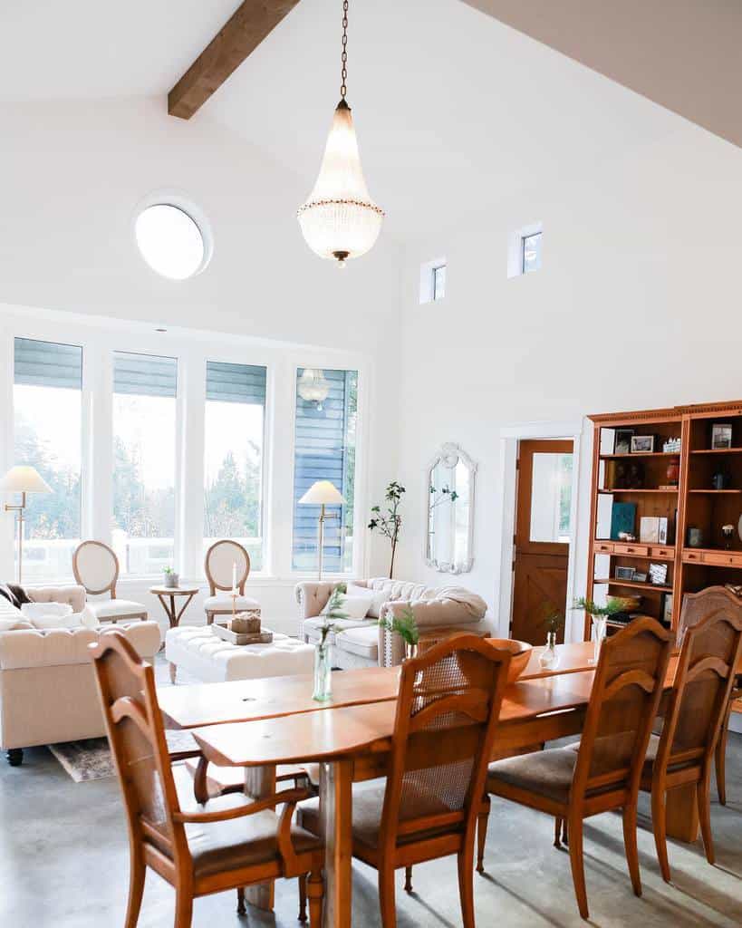 white living and dining room wood cabinet wood dining room table and chairs white sofa and ottoman chandelier