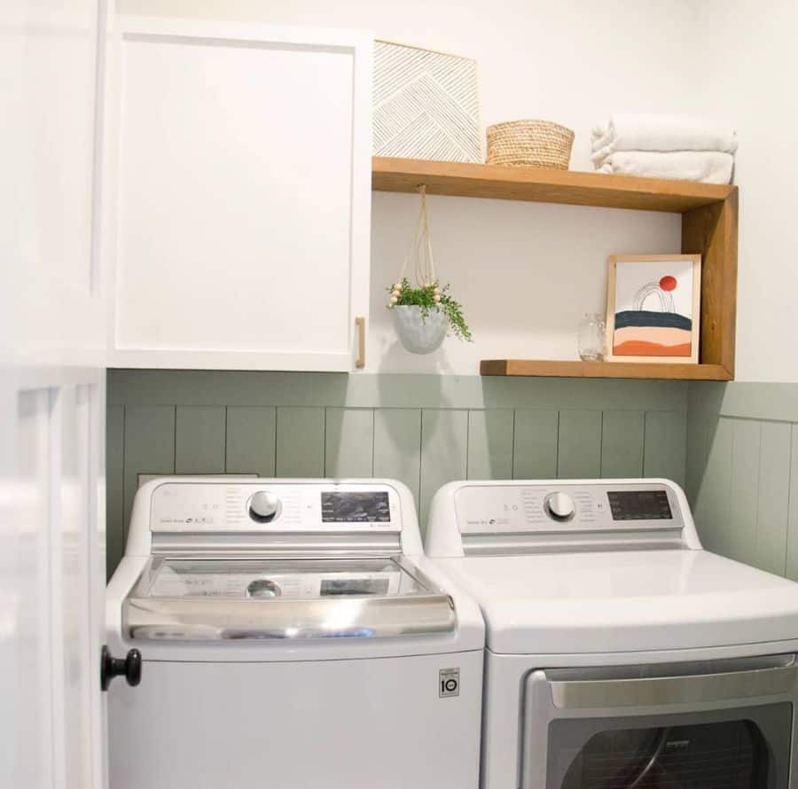 laundry room with white wall cabinet and wood shelving 
