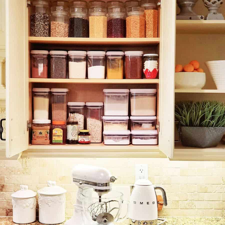 food in jars stored neatly in kitchen cabinet