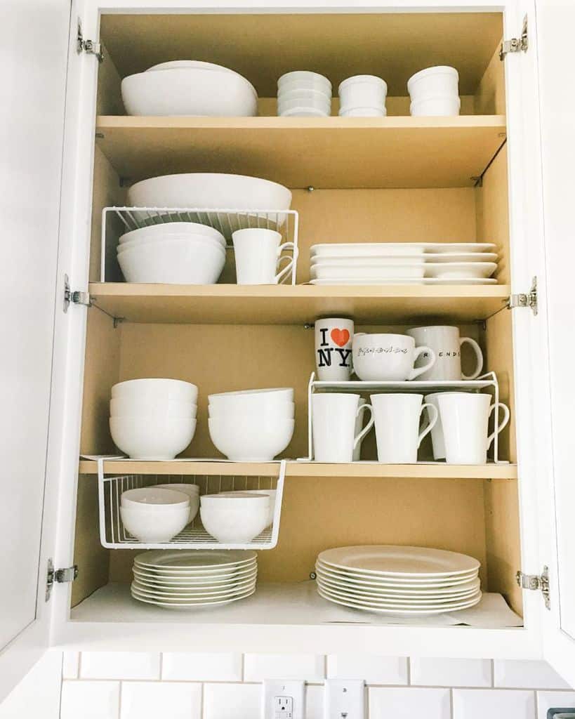 white cutlery neatly stacked in wall cabinet