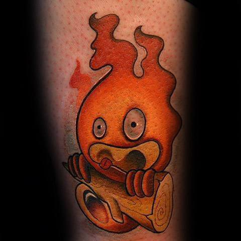 Vivid Calcifer tattoo with glowing orange flames, holding a log and showing a surprised expression with big round eyes.