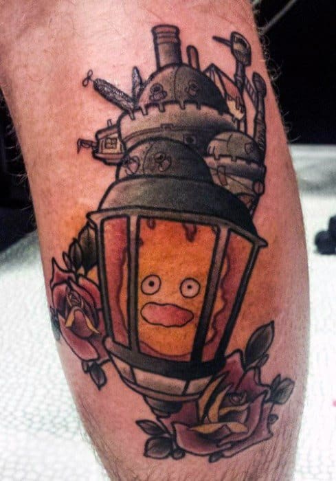 Unique Calcifer tattoo inside a lantern, with Howl’s Moving Castle above and roses below, blending fantasy elements in one design.