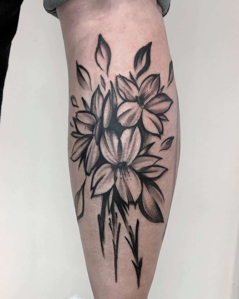 Bold black and grey violet tattoo on the calf, featuring dynamic shading and abstract elements for a striking artistic effect