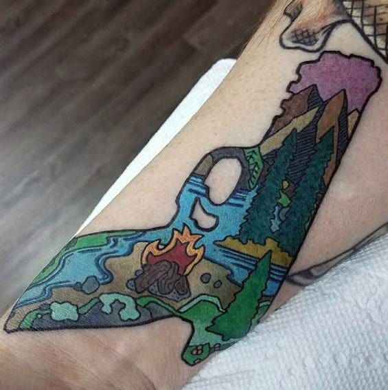 Colorful campfire tattoo shaped like a state, featuring trees, river, mountains, and a tent in a cartoon-style landscape.