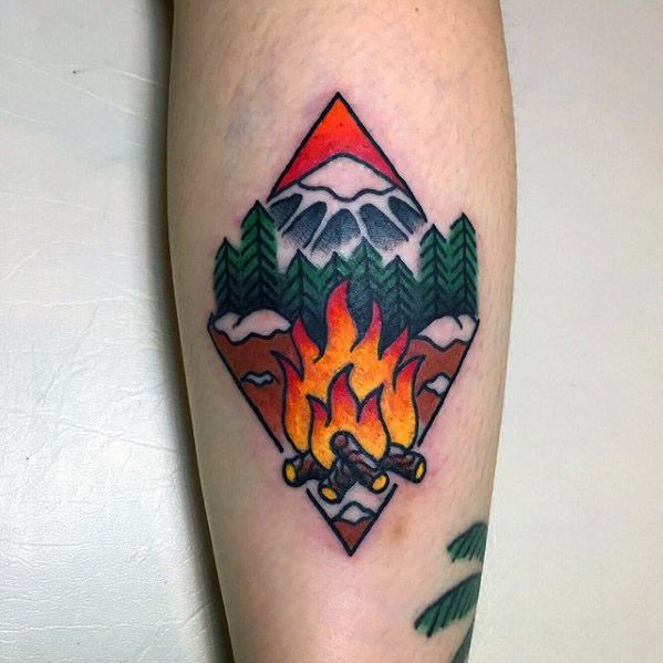 Colorful campfire tattoo framed in a diamond shape with flames, pine trees, snowy mountains, and a red sky backdrop.
