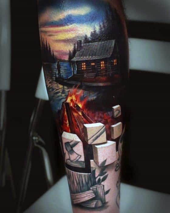 Realistic campfire tattoo with a lakeside cabin, glowing fire, chopped wood, and sunset sky creating a serene outdoor scene.