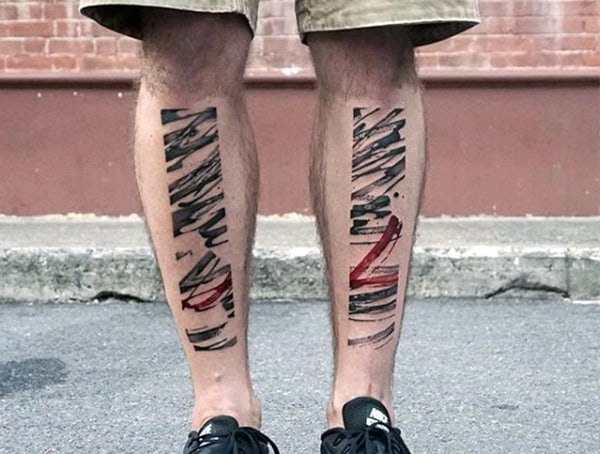 Man with abstract black and red brushstroke tattoos on both calves