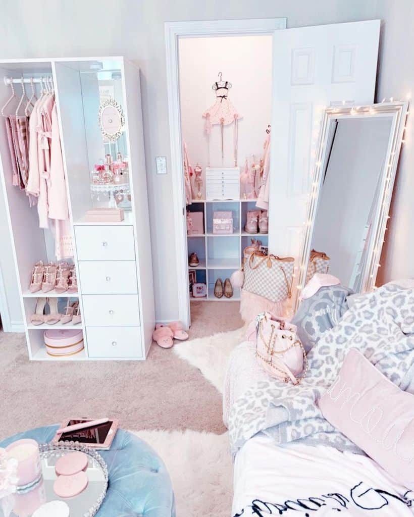 A chic, pink-themed room with a closet, sofa, mirror, and various fashion accessories