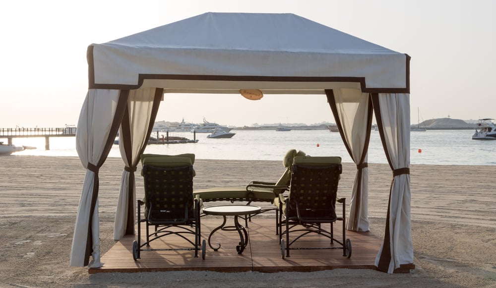 white canopy gazebo beach sun lounges small table