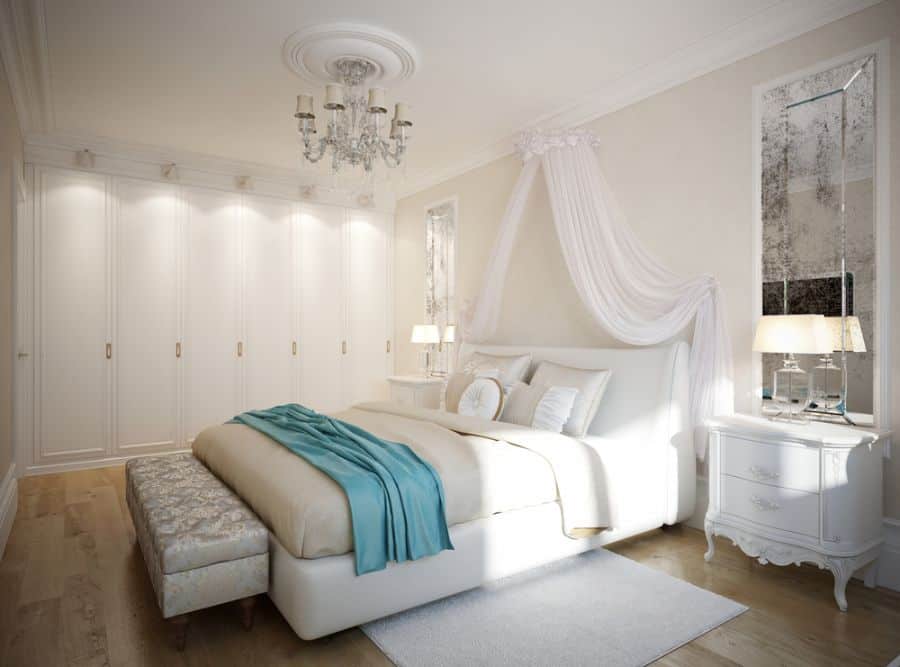 white bedroom with canopy and chandelier