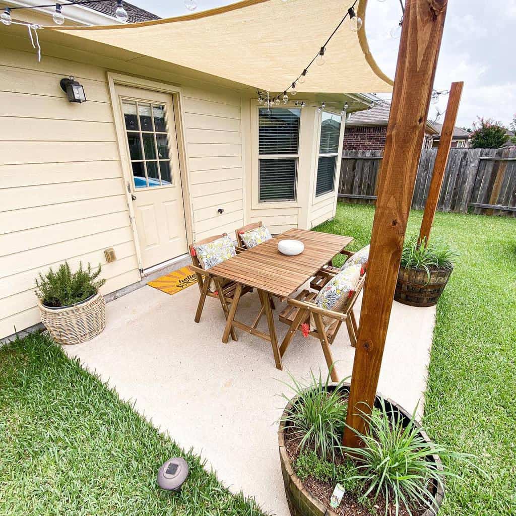 canvas patio shade with wooden table and chairs 