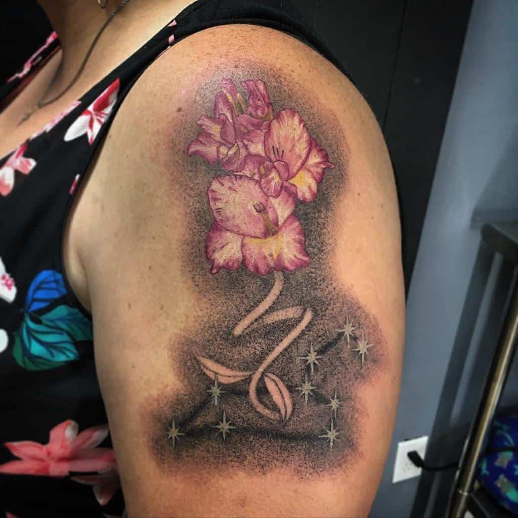 Floral Leo constellation tattoo on shoulder, combining celestial elements with delicate pink blooms for a unique design.