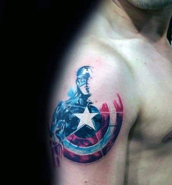 Upper arm tattoo of Captain America in a watercolor style, featuring his iconic shield and star emblem with splashes of red, white, and blue.