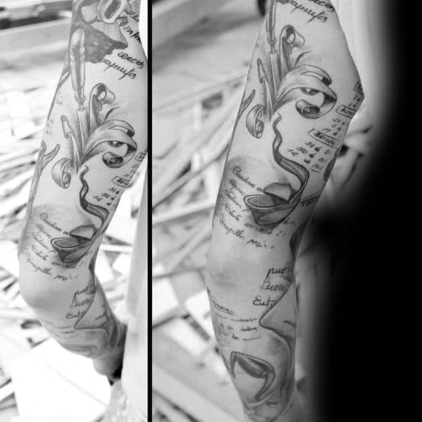 Black and gray tattoo sleeve featuring wood shavings, a hand plane, and handwritten notes, symbolizing precision, craftsmanship, and artistry.