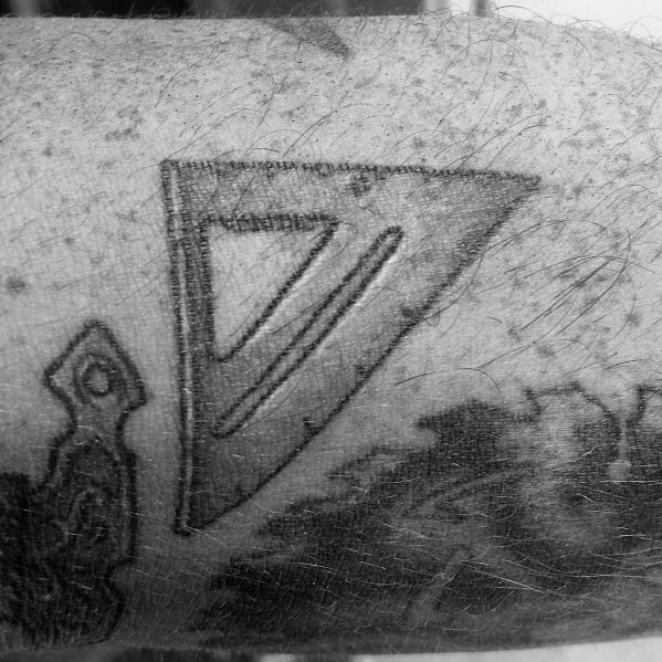 Black and gray tattoo of a triangular ruler, symbolizing precision, measurement, and a deep connection to craftsmanship and woodworking.