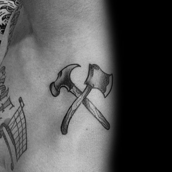 Black and gray tattoo of crossed hammer and axe, symbolizing strength, craftsmanship, and dedication to woodworking and construction.
