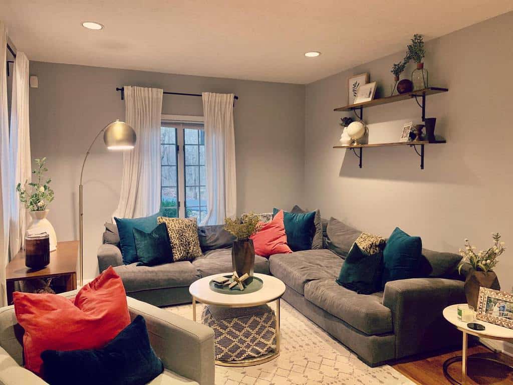 Cozy lounge room with large grey sectional, colorful pillows, and contemporary decor elements.
