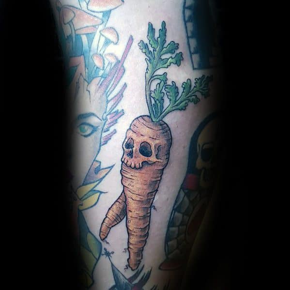 Unique carrot tattoo with a skull-like design, bold shading, and vibrant green leaves, blending organic and gothic elements for a striking look.