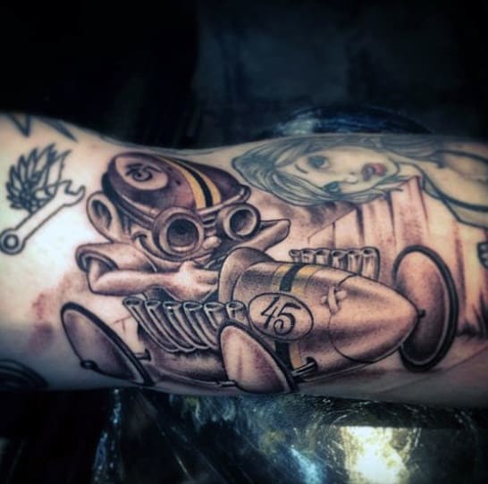 Tattoo of a cartoon-style vintage race car with a driver on an arm
