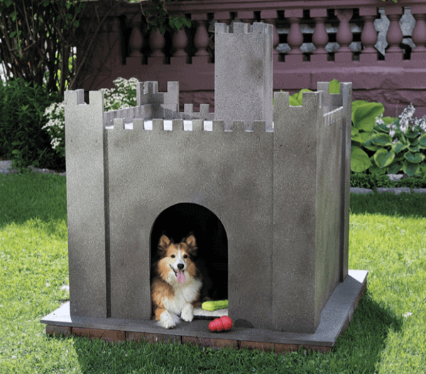 A dog sits inside a fairytale castle-shaped doghouse