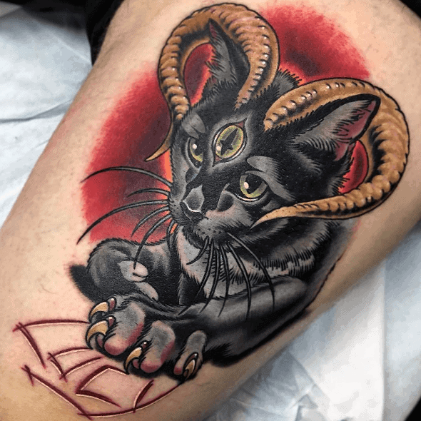 Bold neo-traditional tattoo of a black cat with ram horns, a third eye, and a red aura, creating a mystical and dark aesthetic.