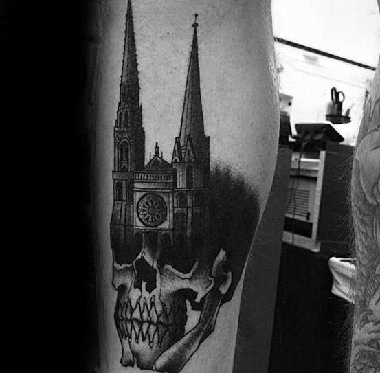 Tattoo of a gothic cathedral with tall spires seamlessly blending into a realistic skull, creating a dark and striking contrast.