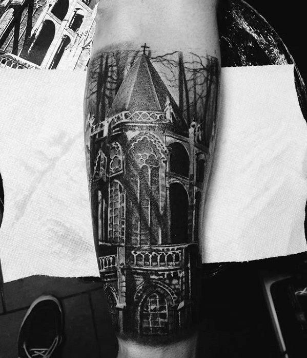 Forearm tattoo of a gothic cathedral with pointed arches, tall spire, and eerie forest background creating a dark, mysterious vibe.