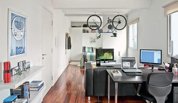 Modern home office with two bikes mounted on a ceiling rack for efficient storage.
