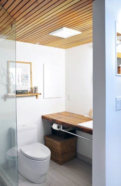 Minimalist bathroom with modern wood panel ceiling, floating vanity, and glass shower enclosure.