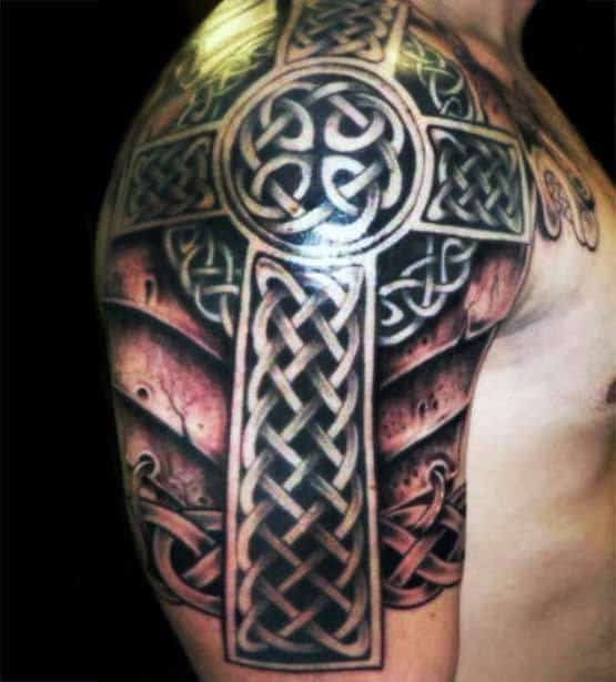 Celtic cross tattoo covering a person's shoulder and upper arm