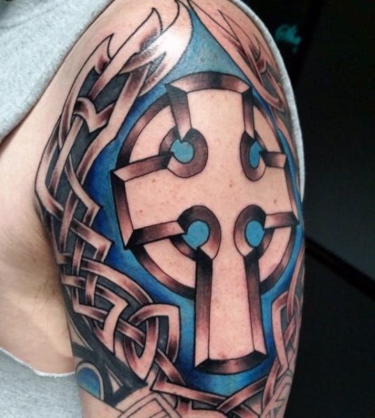 Arm tattoo featuring a Celtic cross with intricate knotwork and blue shading